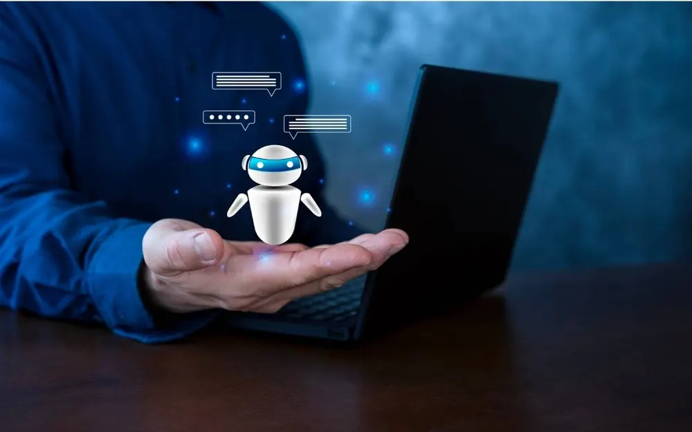 AI assistant icon appearing above a hand next to an open laptop