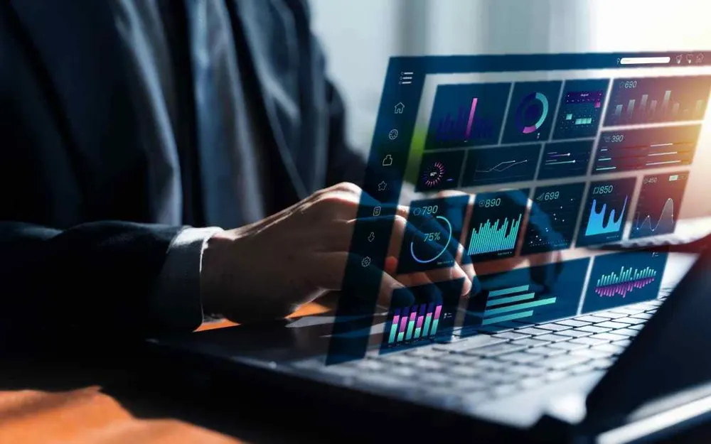 Hand interacting with a holographic AI data dashboard above a laptop