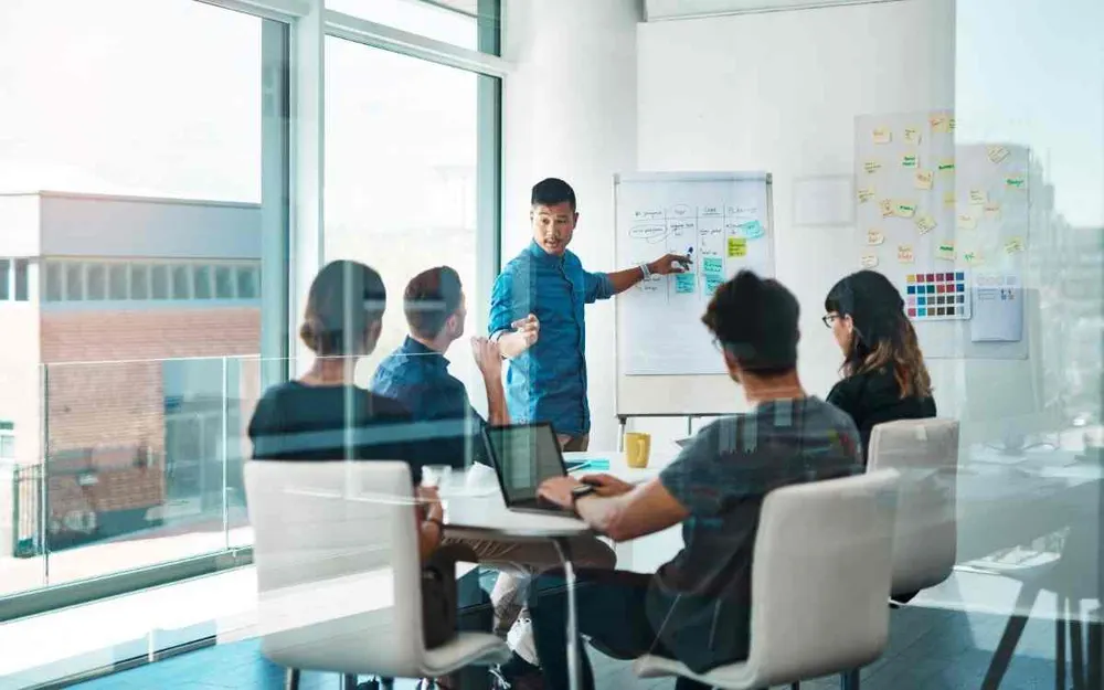Team reviewing a system architecture diagram on a wall-mounted screen