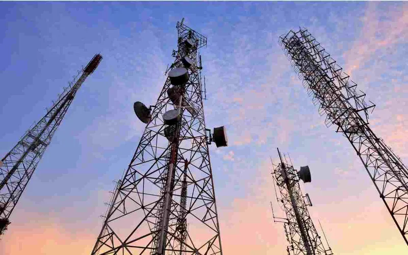 Telecom towers against a sunset sky