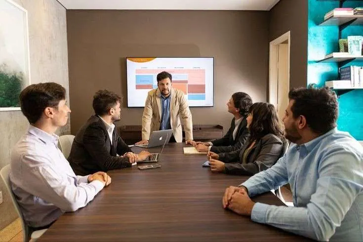 Team reviewing a workflow dashboard on a wall-mounted screen