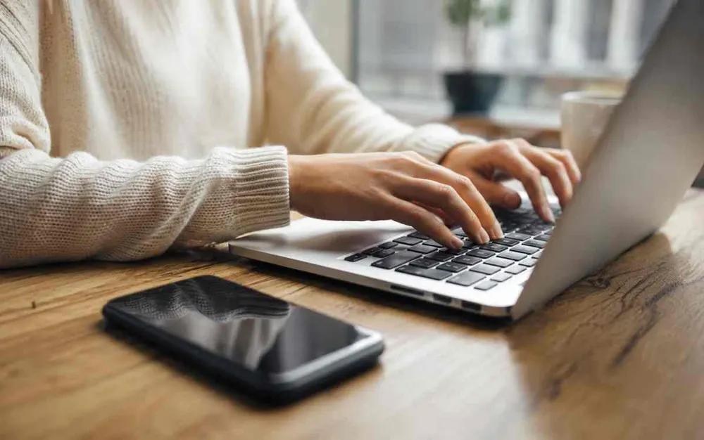 Hands typing on a laptop while choosing between software products